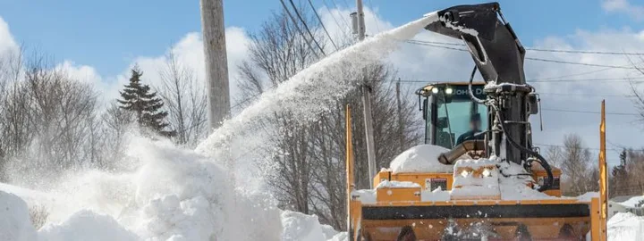 Snow blower clearing a snow-covered road